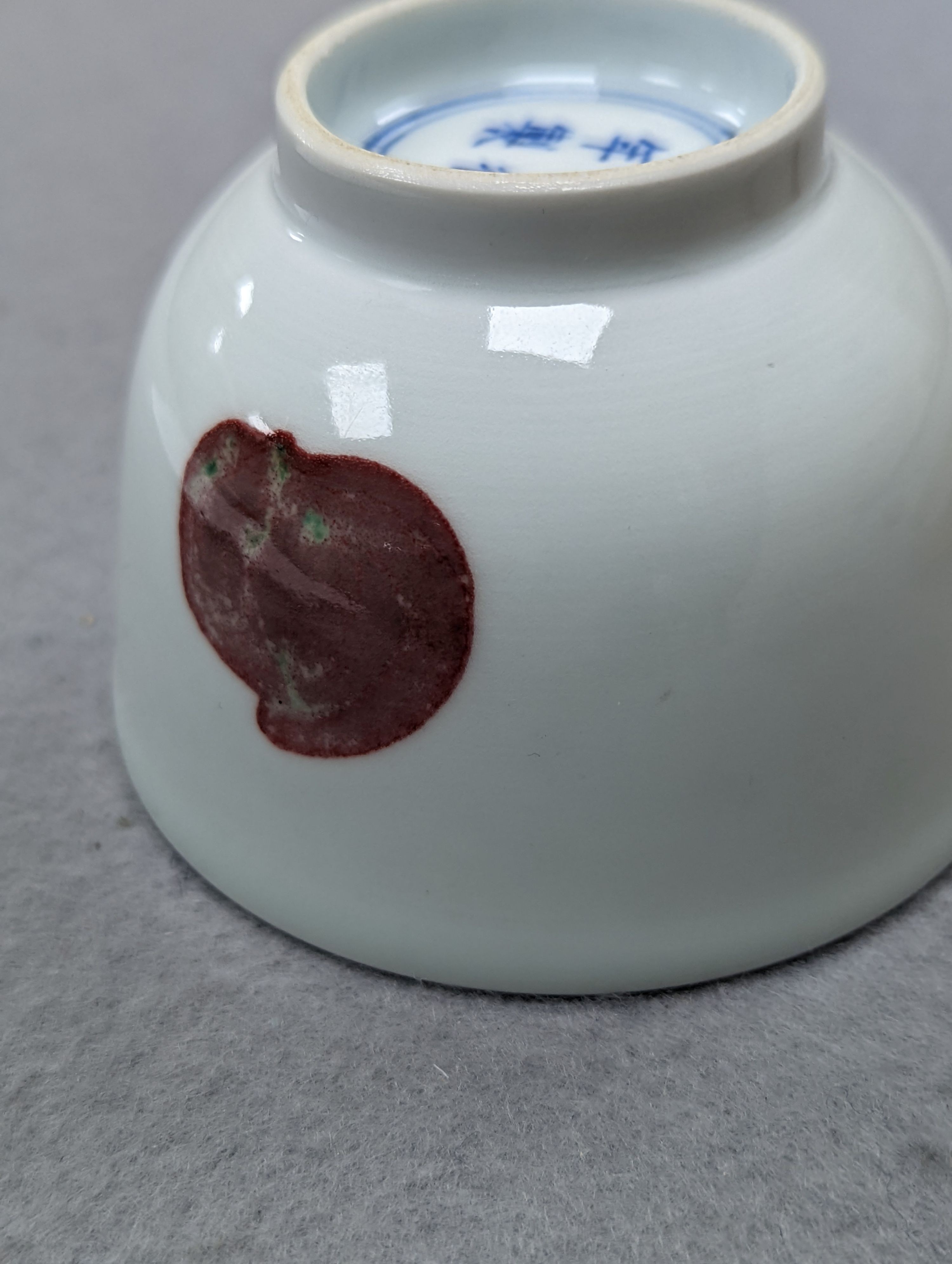 A Chinese porcelain teabowl with ‘fruit’ decoration, an agate bangle and a similar ‘basket’ carving.